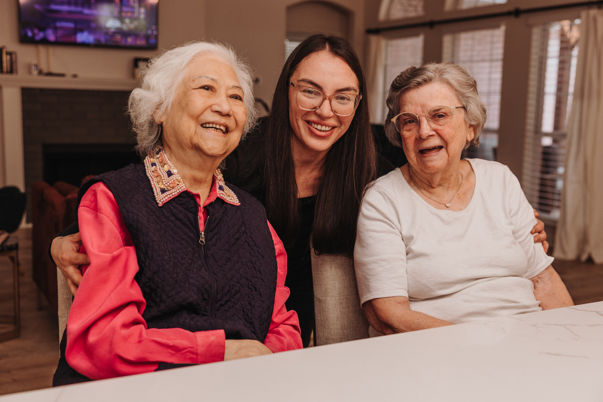 A caregiver and two residents together at the kitchen island at Brentwood
