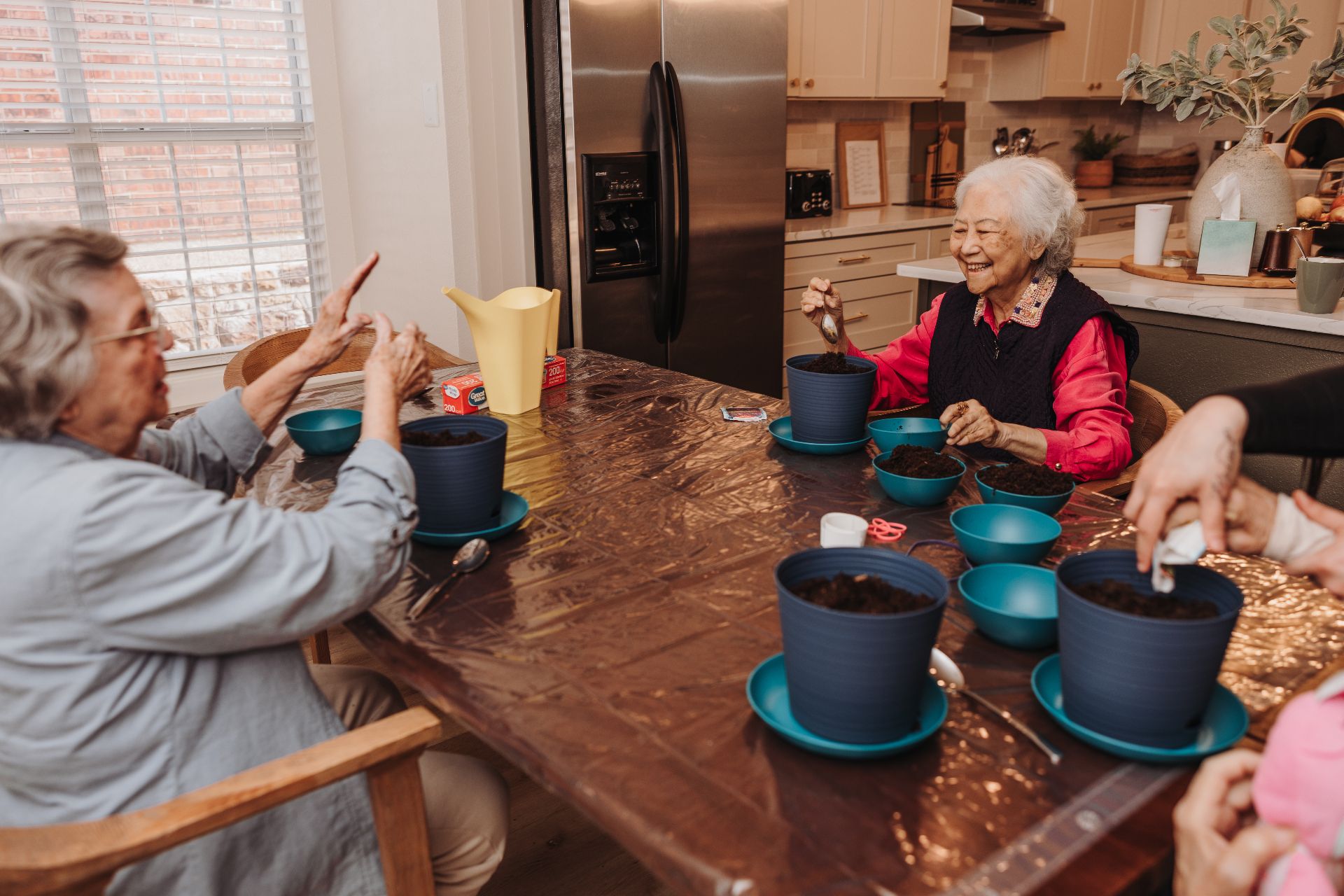 Residents planting herbs together at the kitchen table